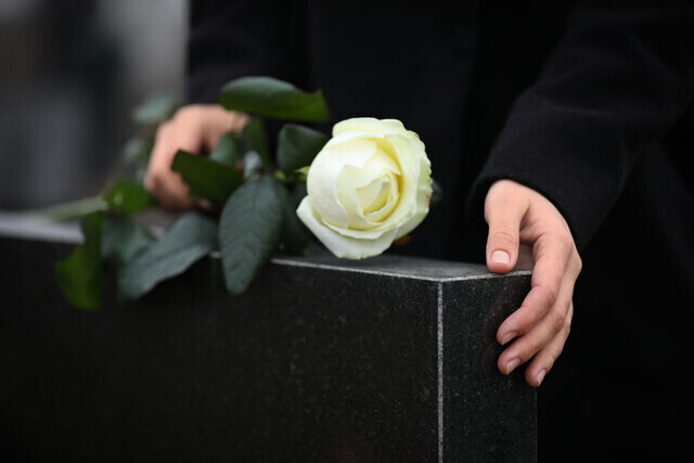 Sort gravsten med hvid rose